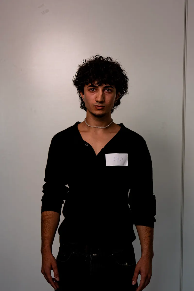 Un candidato de pelo rizado con jersey negro, de frente