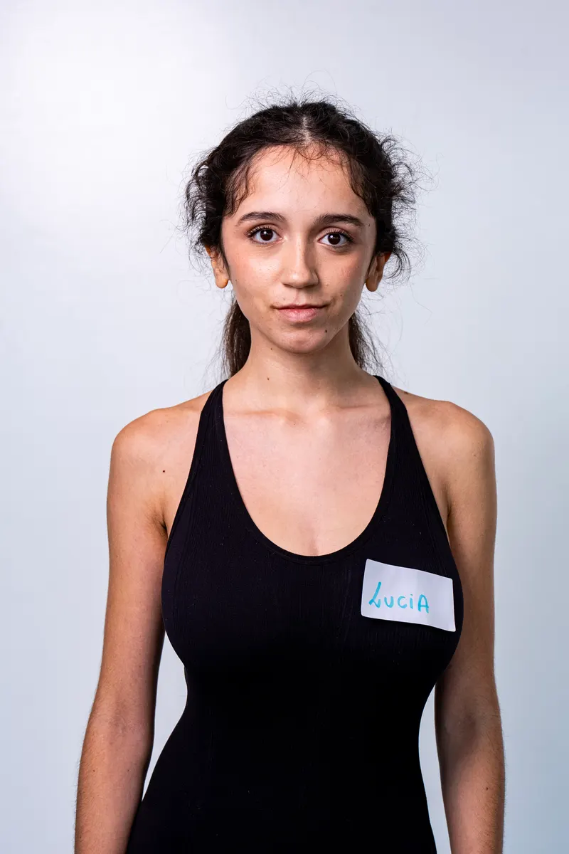 Una candidata con el pelo recogido y camiseta de tirantes negra sonríe a cámara