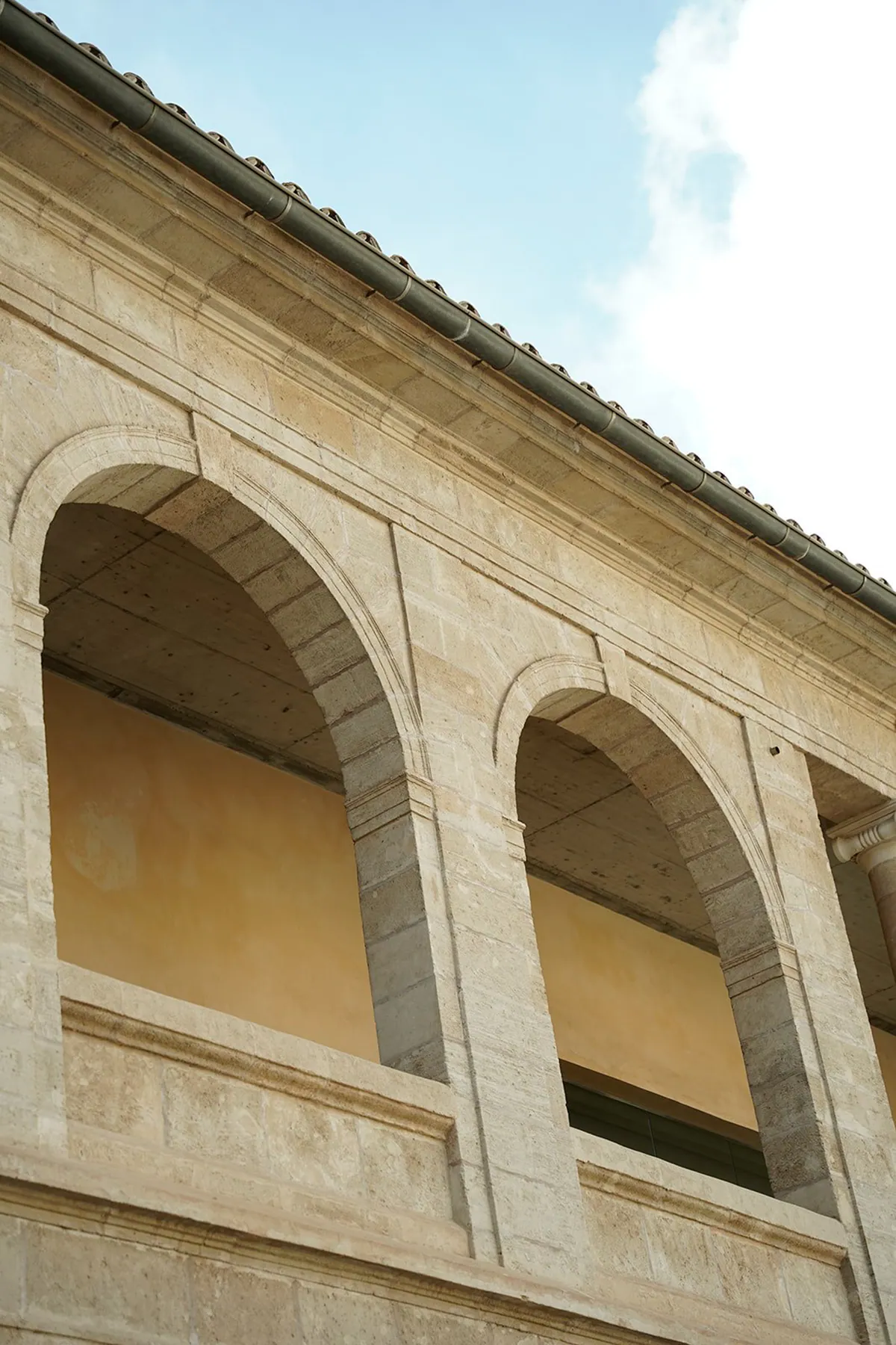 Die steinernen Arkaden der oberen Galerie des Centre Cultural La Misericòrdia in Palma vor dem Himmel