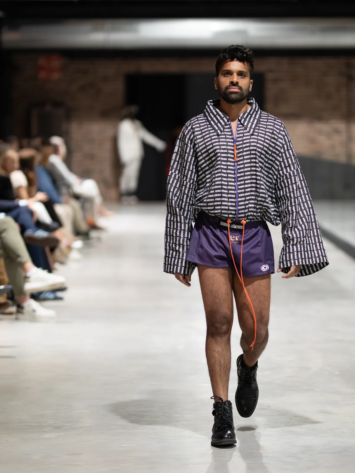 Ein männliches Model läuft vor Publikum über den Laufsteg von Mallorca Fashion Days 2025