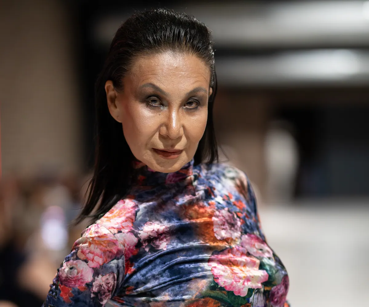 Ein Model in einem geblümten Samtkleid posiert am Ende des Laufstegs von Mallorca Fashion Days 2025