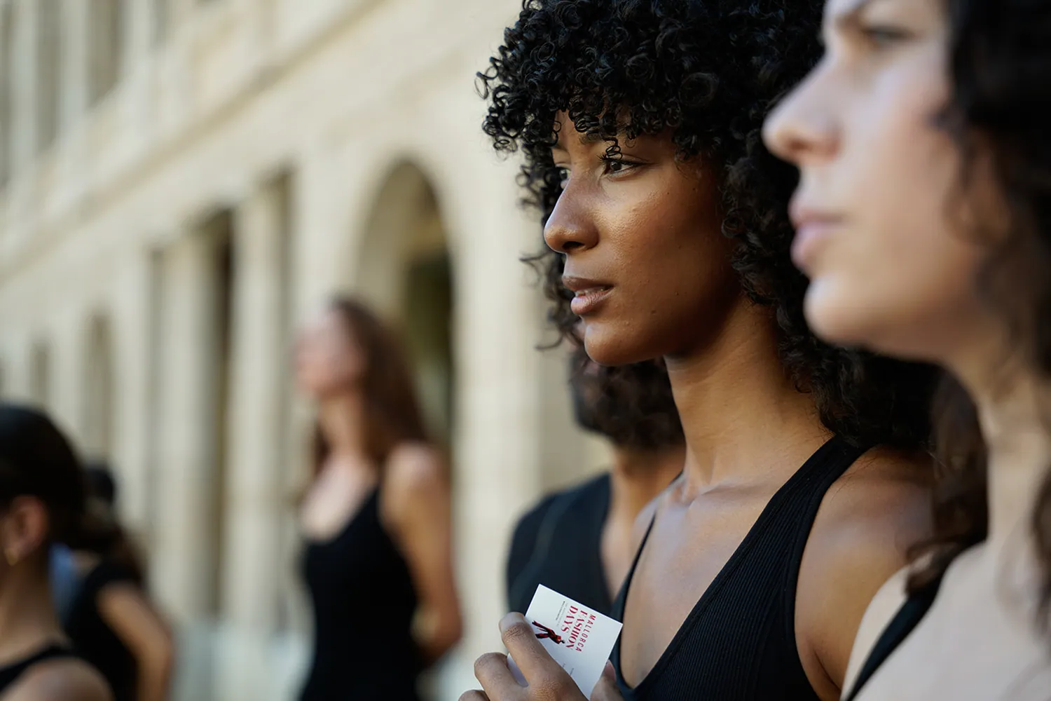 Ein Model wartet beim Casting 2025 in La Misericòrdia auf seinen Einsatz, die Karte von Mallorca Fashion Days in der Hand
