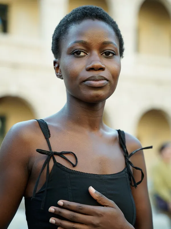 Ein Model beim Casting 2025 im Innenhof von La Misericòrdia, mit der Hand auf der Brust